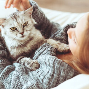 A girl petting a cat.