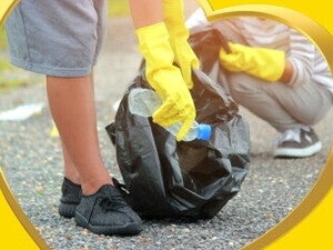 2 teenagers picking up plastics on a road